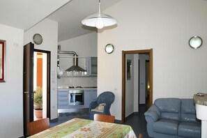 Ein Zimmer mit Bett, Sessel, Sofa, Tisch und einer Küchenzeile.