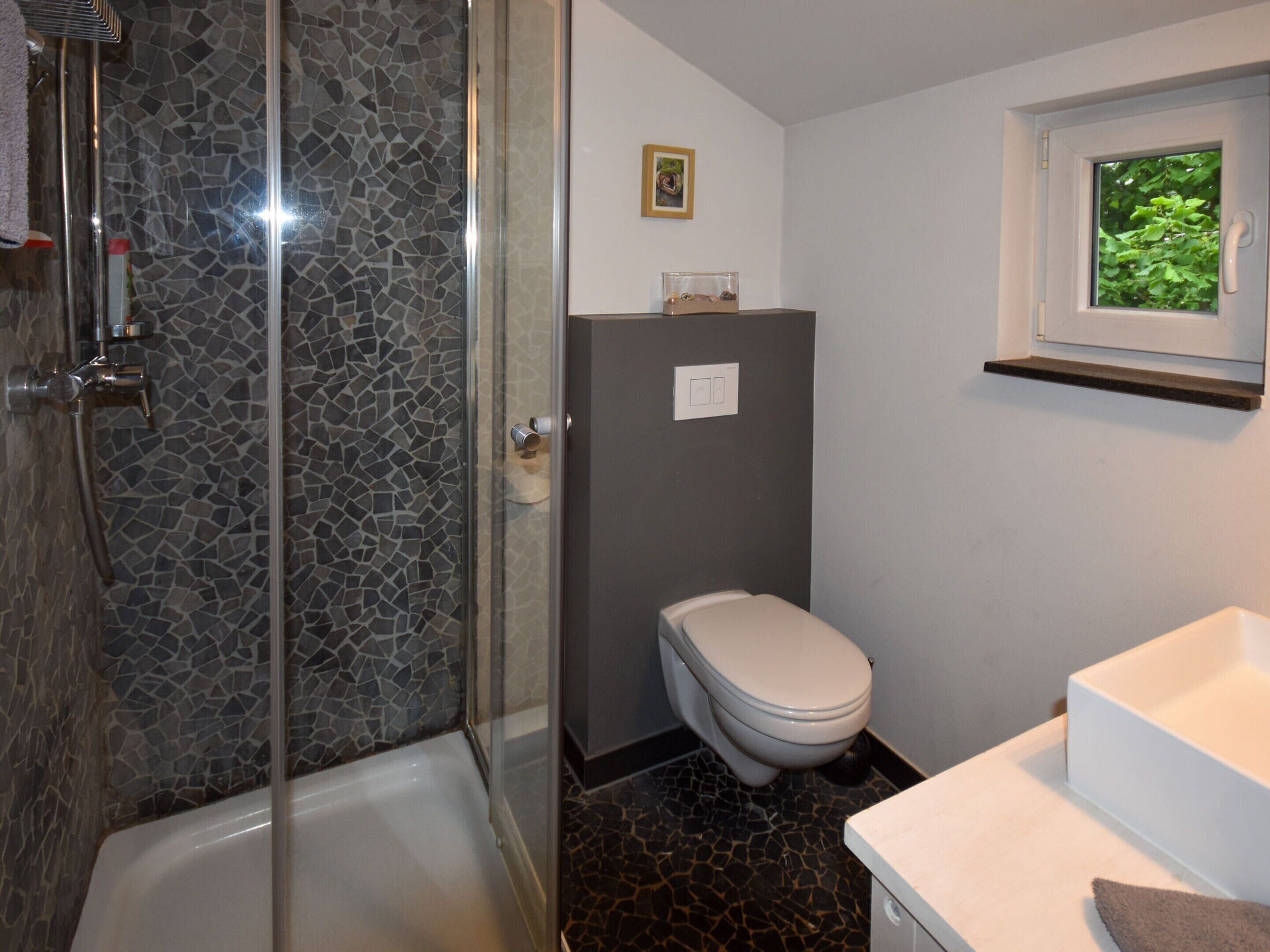 A bathroom with a shower, toilet, and sink.