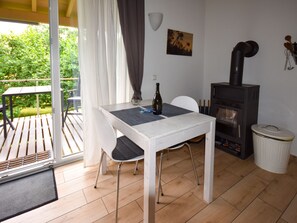 Un comedor con una mesa, sillas, una botella y una chimenea.