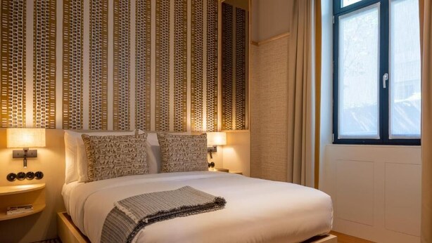 A neatly arranged bedroom with a bed, bedside lamps, and a window with curtains. - Casa da Marechal - Boutique House by Oporto Collection (Porto)