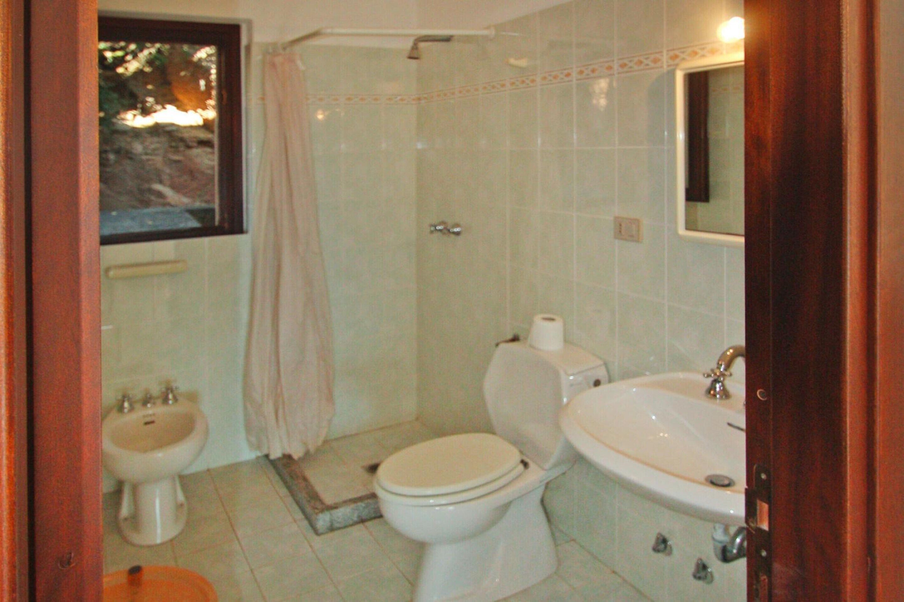 Un baño con inodoro, bidé y lavamanos.