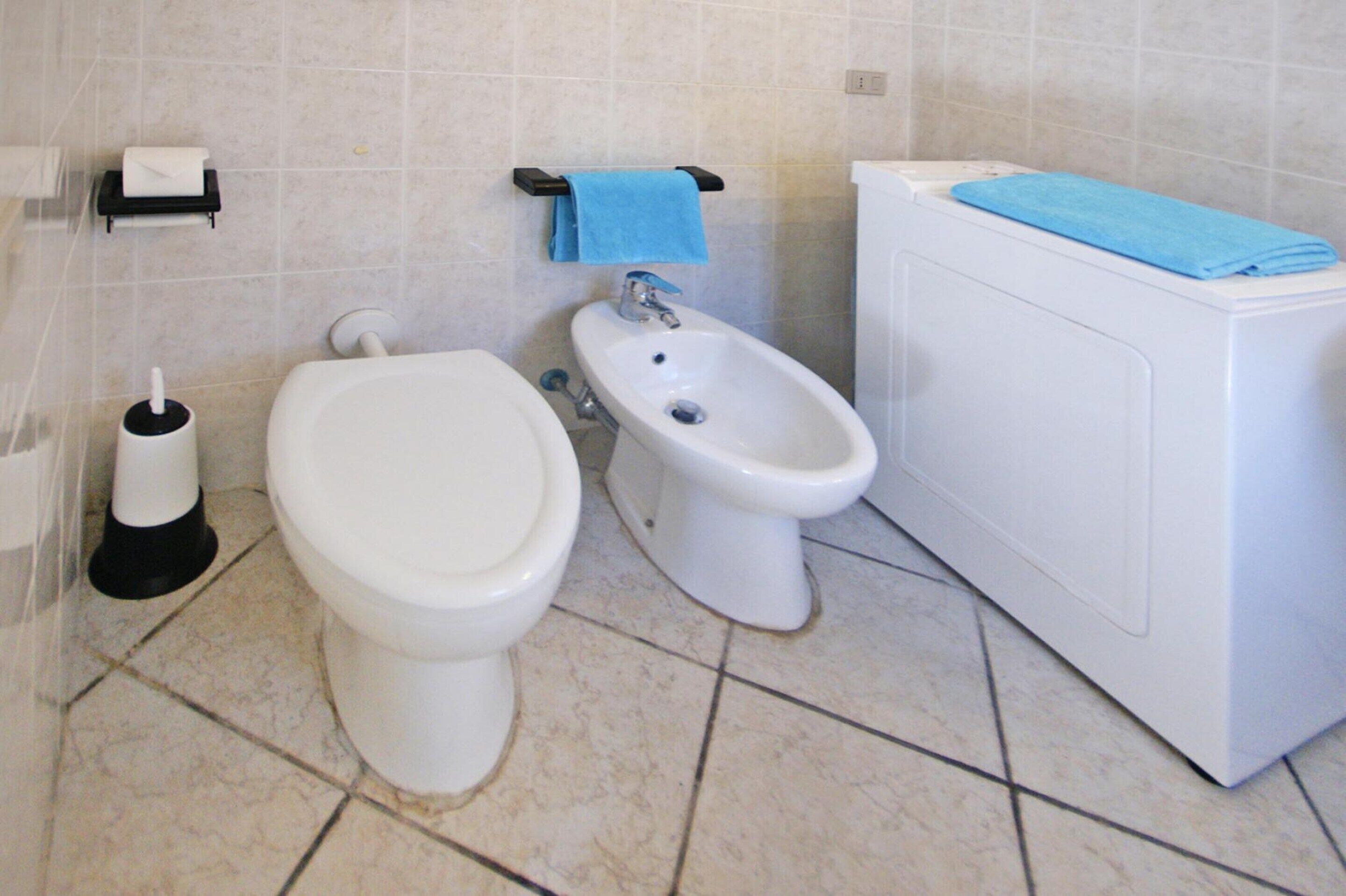 A bathroom with a toilet, bidet, and a bathtub.
