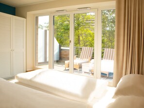 A bedroom with a large sliding glass door leading to a balcony with a view of trees and a building. - Aalernhus Ferienhaus mit Hotel-spa St.peter-ording (St. Peter-Ording)