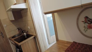 A compact kitchen with a sink, kettle, and a small window. - Seaside Apartment in Dziwnow Baltic (Dziwnów)