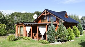 A wooden cabin with a sloped roof, large windows, and a satellite dish. - Cozy Holiday Home, Junoszyno (Stegna)