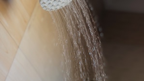 A showerhead with water flowing from it. - Cam Lodge (Tanga)