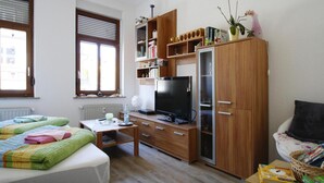 A bedroom with a bed, a desk, a television, and a wardrobe. - Wohnung in Ellefeld Nahe Skipisten (Ellefeld)