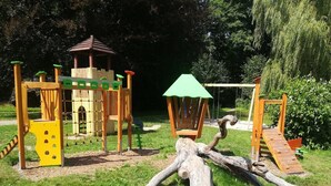 A playground with wooden climbing structures, slides, and a log bridge. - Wohnung in Ellefeld Nahe Skipisten (Ellefeld)