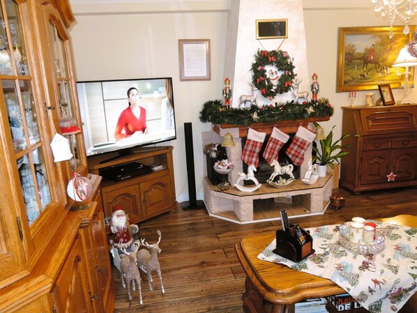 A cozy living room with a television, a fireplace with stockings, and Christmas decorations. - Holiday Home Kolczewo Near Lakes and Forests (gmina Wolin)