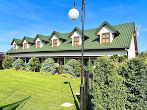 A two-story house with a green roof and multiple windows. - Comfortable Holiday Homes Close to the Beach (Mielno)