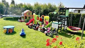 A playground with various play structures, a trampoline, and a small house. - Comfortable Holiday Homes Close to the Beach (Mielno)