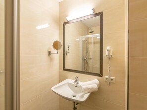 Ein Badezimmer mit Waschbecken, Spiegel und Dusche.