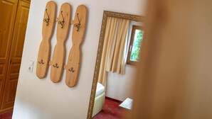 Une pièce dont les murs sont décorés de panneaux en bois, avec un miroir et une fenêtre ornée de rideaux.