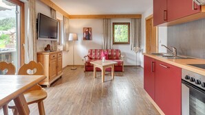 Un espace de vie compact comprenant une kitchenette, un coin repas et un canapé.