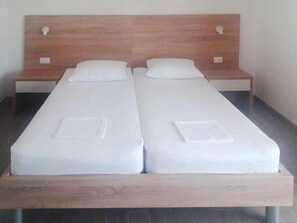 A double bed with a wooden headboard and two bedside tables. - Cozy Starigrad Apartment for 4 (Starigrad)