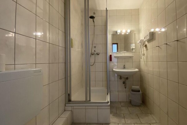 Une salle de bain moderne avec une douche à parois de verre, un lavabo et des toilettes.
