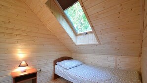 A small, wooden cabin room with a single bed, a nightstand, and a window. - Year-round Holiday House Near the Sea, Pustkowo (Rewal)
