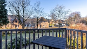A wooden deck with a bench, overlooking a residential area with houses and trees. - Comfortable Holiday Apartment in St. Peter Ording (St. Peter-Ording)