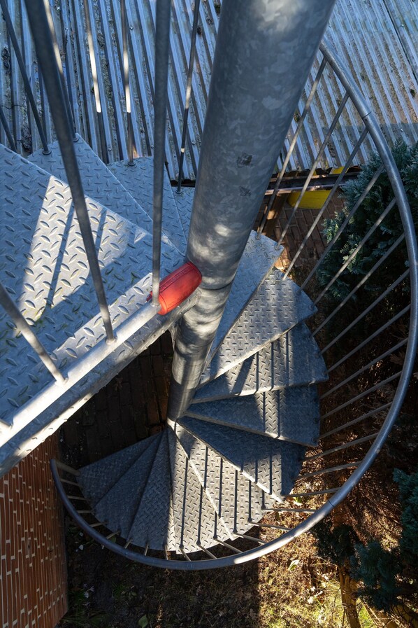 A spiral staircase with metal railings and a red object on the steps. - Comfortable Holiday Apartment in St. Peter Ording (St. Peter-Ording)