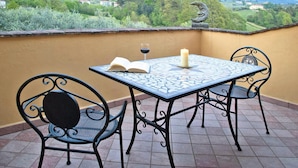 A terrace with a table, two chairs, an open book, a glass of red wine, and a candle. - Villa in Vinci With Pool & Panoramic Views (Lamporecchio)