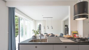 Une cuisine moderne dotée d’un îlot central, d’un évier en acier inoxydable et d’un éclairage au plafond.