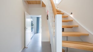 Un escalier moderne avec des marches en bois et une rampe blanche.