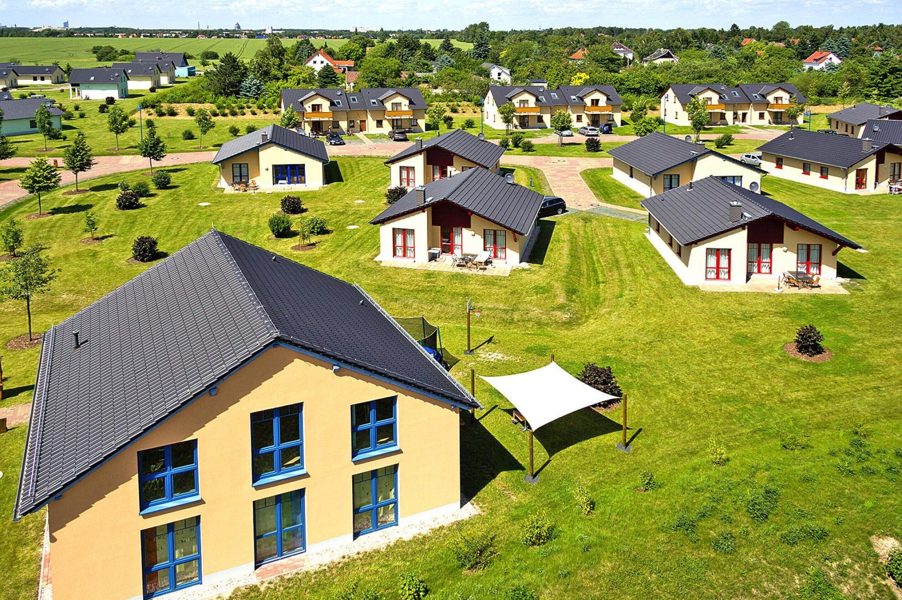 A residential area with multiple houses featuring a consistent architectural style, including pitched roofs and a mix of single and two-story buildings.