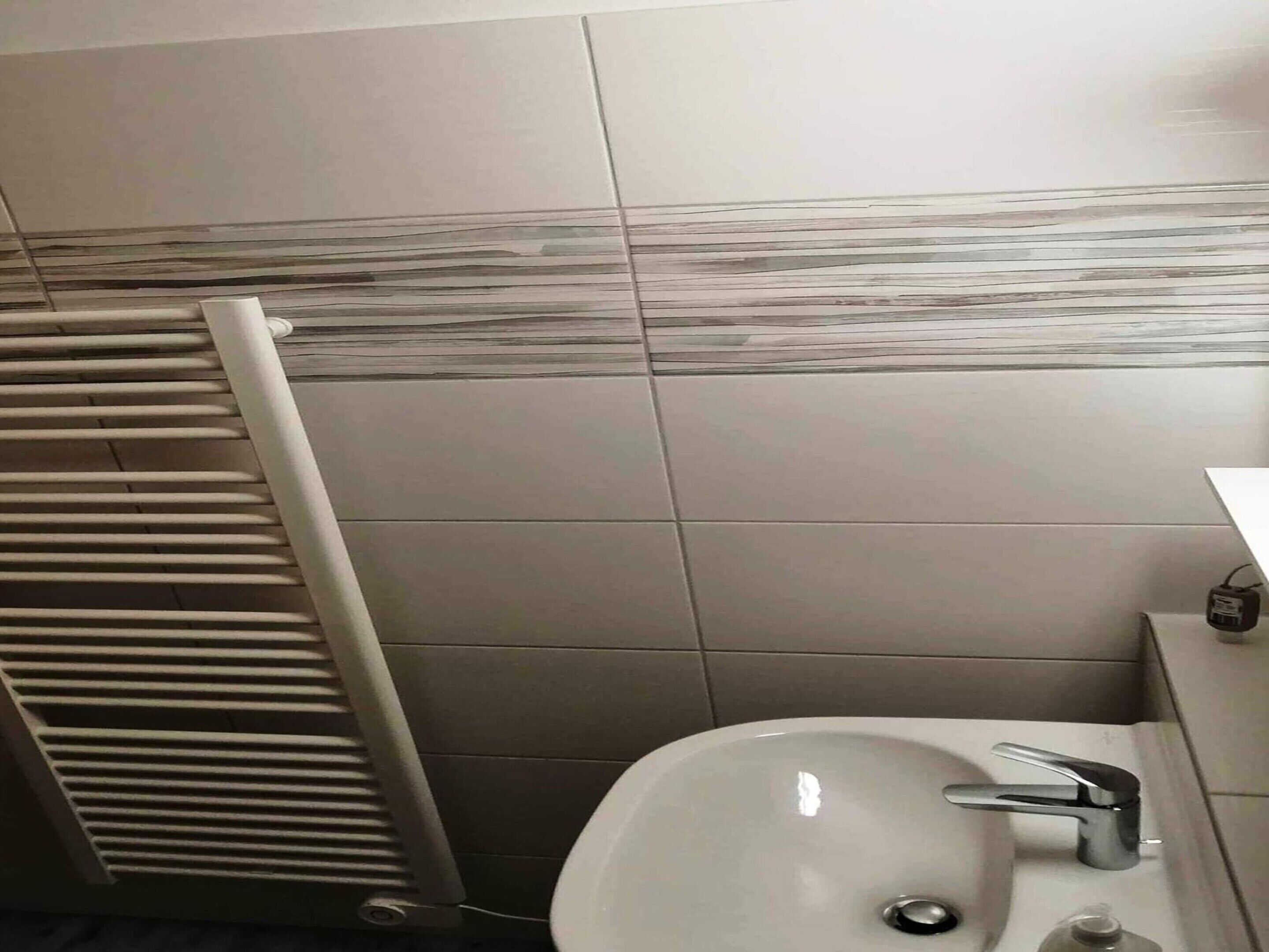 A bathroom with a white sink, a mirror, and a towel rack.