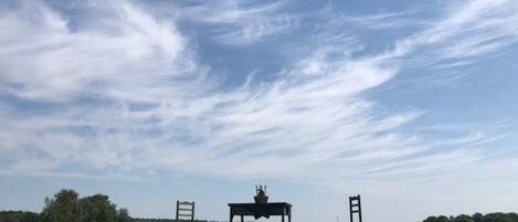 An open field with a table and two chairs under a clear sky.