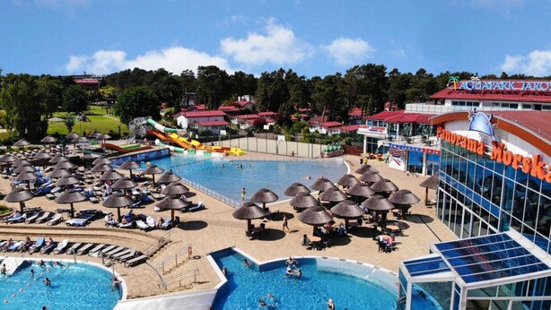 A large outdoor swimming pool area with multiple pools, lounge chairs, umbrellas, and a water slide. - Cozy Cottage With a Huge Garden, Jaroslawiec (Postomino)