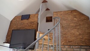 Eine Treppe mit Holzverkleidung und Metallgeländern, die in eine untere Ebene führt.