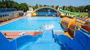 Een zwembad met een waterglijbaan en een grote waterpomp.