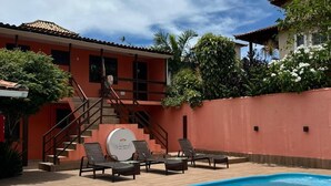 A swimming pool with lounge chairs and a staircase leading to a building. - Encanto dos Anjos (Búzios)