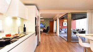 A modern kitchen with white cabinets, a wooden countertop, and a dining area with a table and chairs. - Holiday Home, Maspalomas (San Bartolomé de Tirajana)