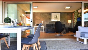 A modern living room with a sofa, chairs, and a dining area with a table and chairs. - Holiday Home, Maspalomas (San Bartolomé de Tirajana)