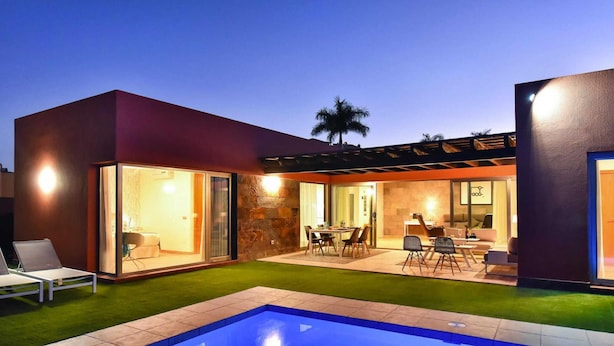 A modern house with a swimming pool, outdoor seating, and a well-lit patio area. - Holiday Home, Maspalomas (San Bartolomé de Tirajana)
