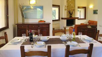 A dining area with a table set for two, a television, and a fireplace.