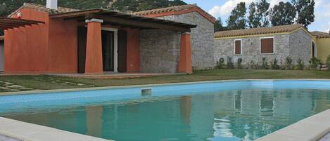 Una piscina con un edificio in pietra sullo sfondo.