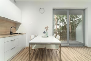 A modern kitchen with white cabinets, a wooden countertop, and a black faucet. - Holiday Studio Very Close to the Seaside Beach (Rewal)