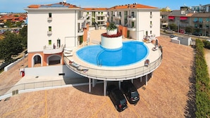 Un hôtel doté d’une piscine centrale, de nombreux balcons et d’un espace de stationnement.