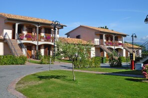 A hotel with multiple balconies, outdoor staircases, and a well-maintained garden. - Tourist Resort, Grosseto (Sorano)
