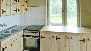 Et køkken med træskabe, en komfur og en vask.