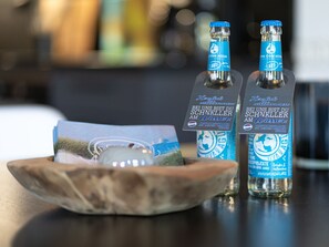 Two bottles of water with labels on a wooden tray. - Landhaus in Vollerwiek (Vollerwiek)