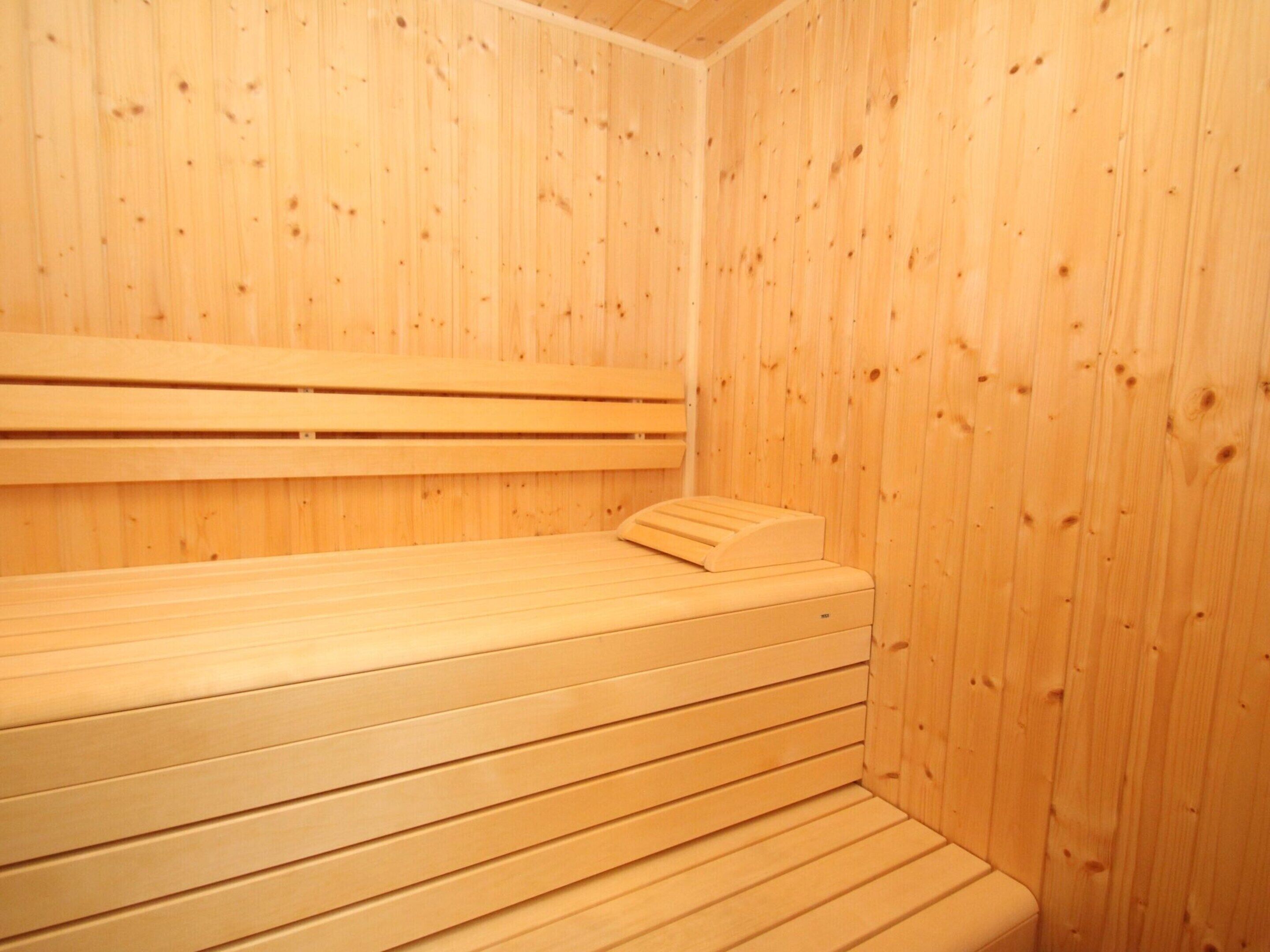 Un cuarto de sauna con bancos y paredes de madera.