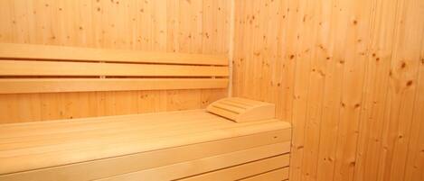 Un cuarto de sauna con bancos y paredes de madera.