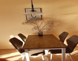 Un tavolo da pranzo in legno con sei sedie, un lampadario e un quadro appeso al muro.