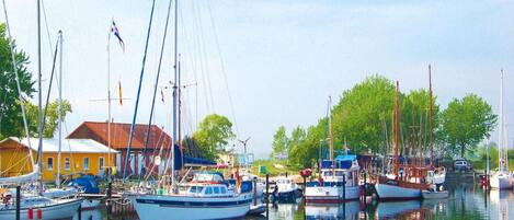 A marina with several boats docked, a yellow building, and a clear sky.