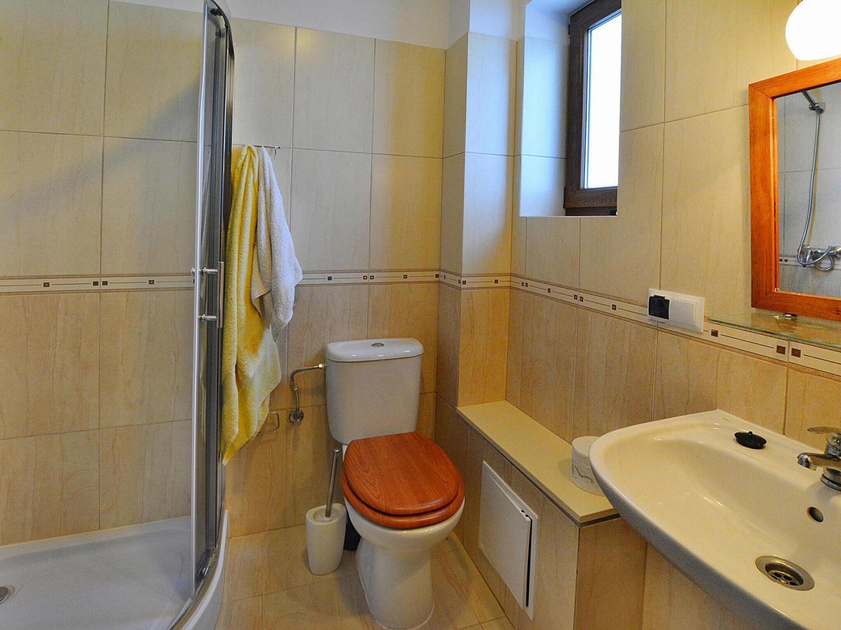 A bathroom with a shower, toilet, and sink.