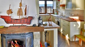 A kitchen with a fireplace, wooden counter, and a view of the sea. - Holiday Home on the Lake Shore, Boat Included (gmina Manowo)