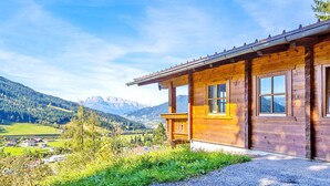 A wooden cabin with a view of mountains and a valley. - Chalet in Eben With Panoramic Mountain Views (Eben im Pongau)